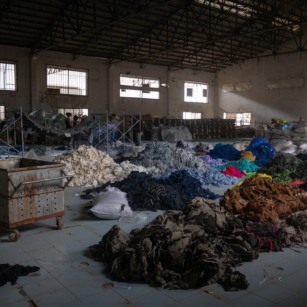 mucchi di tessuti all'interno di un grande magazzino industriale 